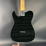 Black electric guitar body on a stand with a gray background