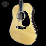 Acoustic guitar with a visible brand logo on a black background