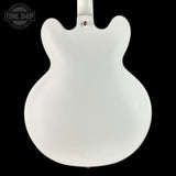 White electric guitar body on a black background with 'Tone Shop' logo.