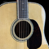 Close-up of an acoustic guitar's soundhole and headstock on a black background