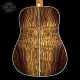 Close-up of a wooden acoustic guitar body with 'Tone Shop' logo.