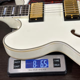 White electric guitar on a digital scale displaying weight