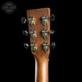 Close-up of a guitar headstock with tuning pegs on a black background, featuring the Tone Shop logo.