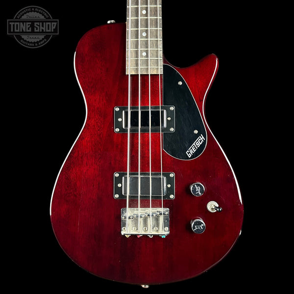 Red electric bass guitar with Gretsch logo on a black background