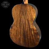 Close-up of a wooden guitar body with 'Tone Shop' logo in the corner.