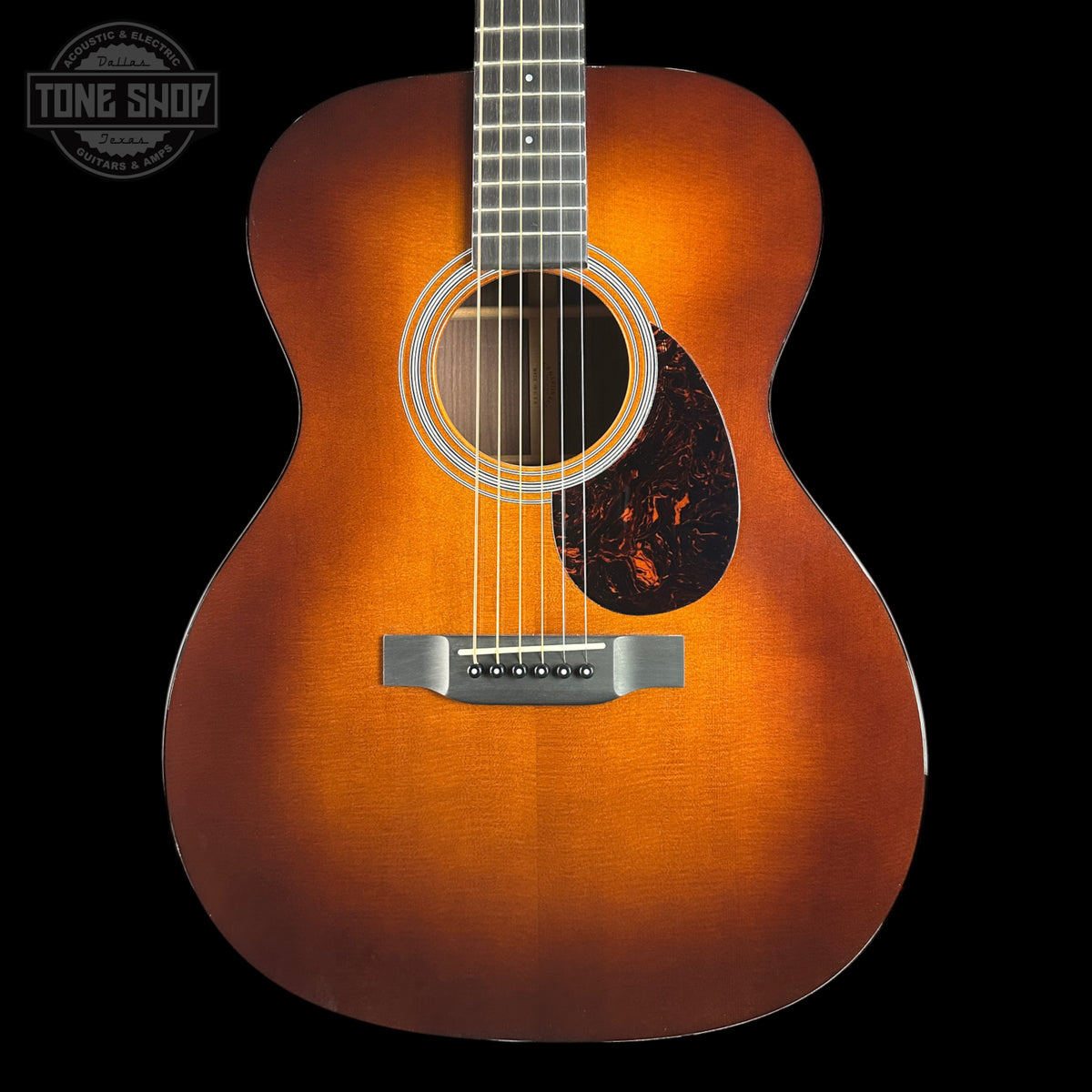 A classic acoustic guitar with a natural sunburst finish, shown from the front against a solid black background. The brand 'Tone Shop' is visible as a watermark in the top-left corner.