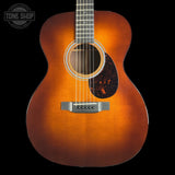 A classic acoustic guitar with a natural sunburst finish, shown from the front against a solid black background. The brand 'Tone Shop' is visible as a watermark in the top-left corner.