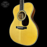 Acoustic guitar with a visible brand logo on a black background