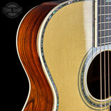 Close-up of a wooden acoustic guitar with a visible brand logo in the corner.