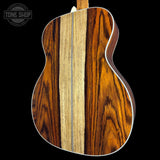 Close-up of a guitar's wooden back with a visible brand logo in the corner.