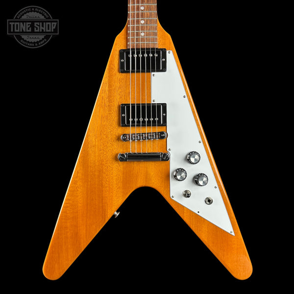 Wooden electric guitar with a white pickguard on a black background, featuring the Tone Shop logo.