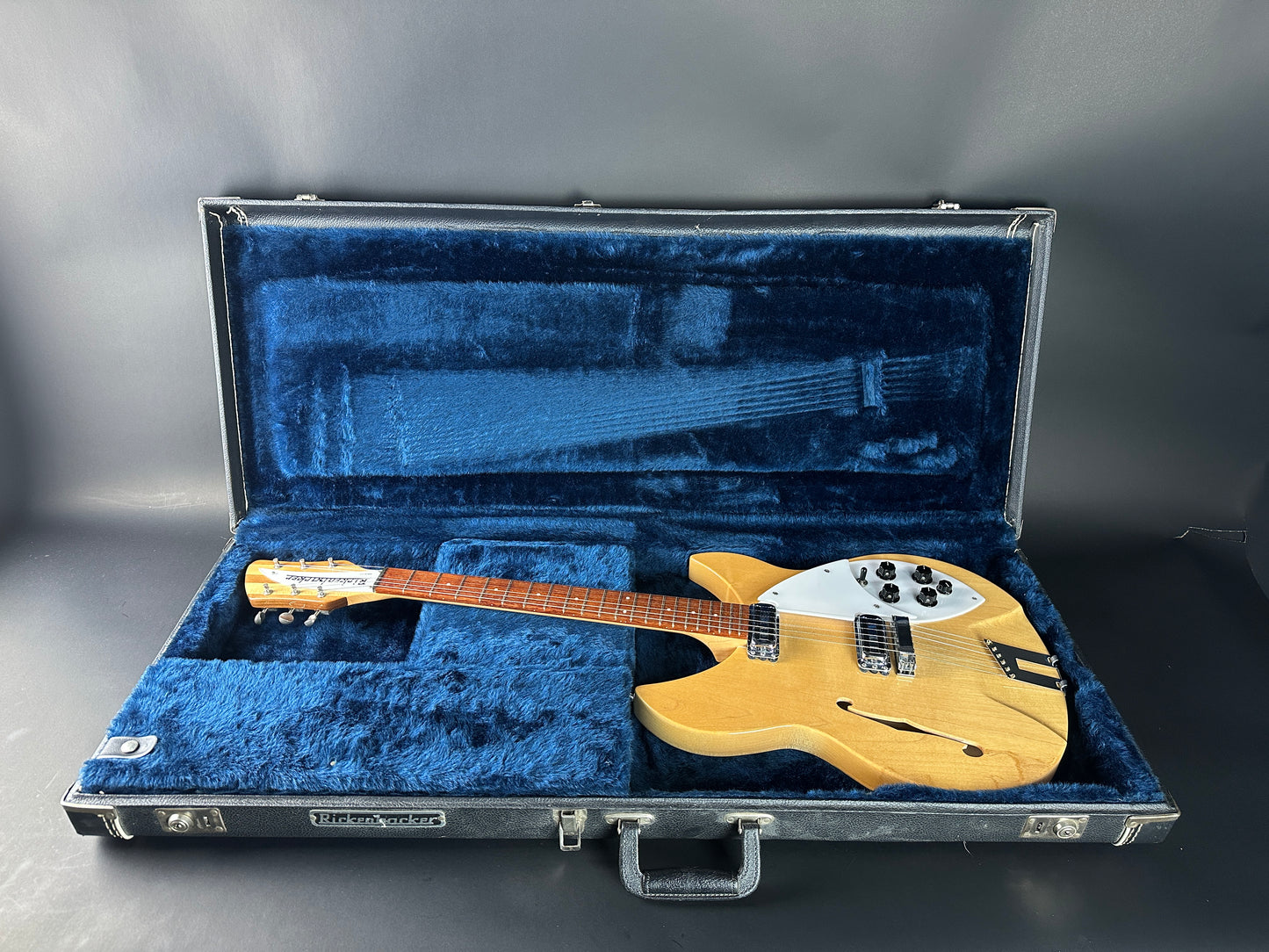 Electric guitar in a blue-lined case on a gray background