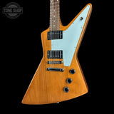 Wooden electric guitar with a white pickguard on a black background, featuring the Tone Shop logo.