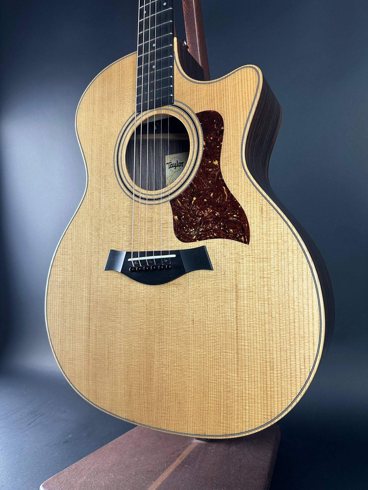 Acoustic guitar with a natural wood finish on a dark background