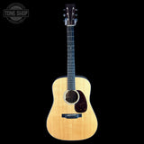 Acoustic guitar with a visible brand logo on a black background