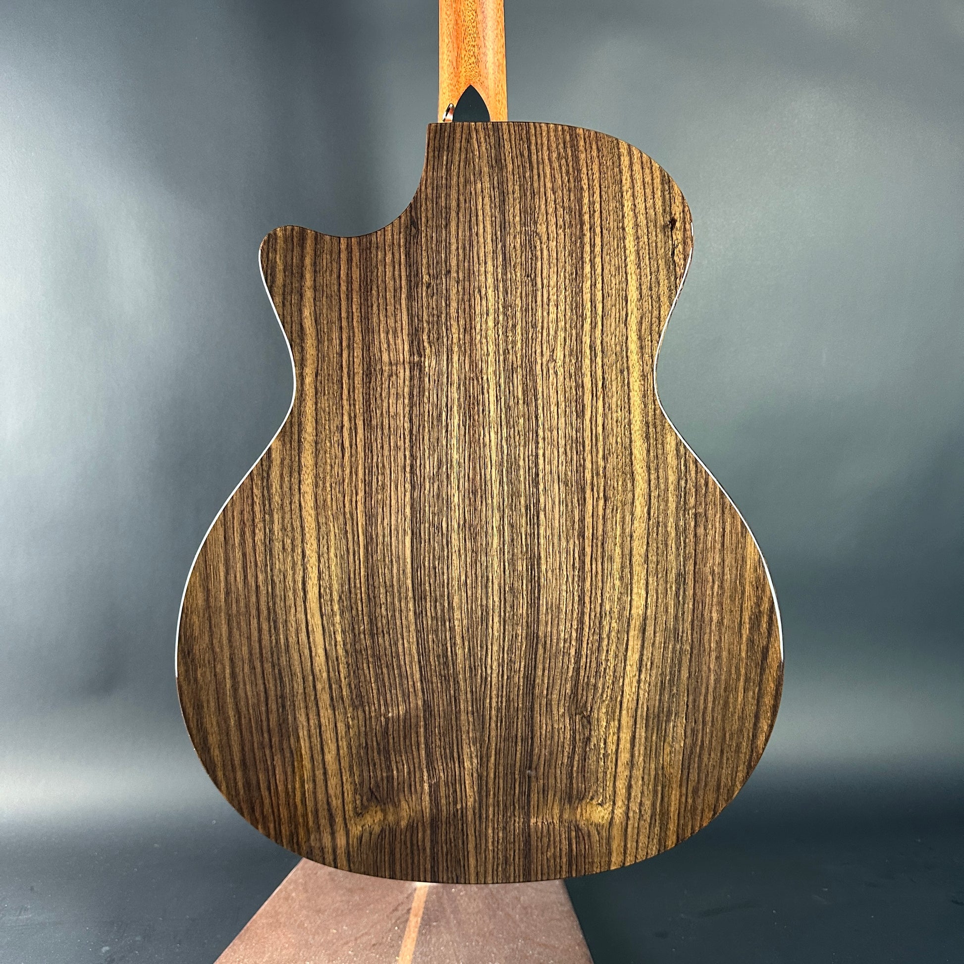 Wooden guitar body on a gray background