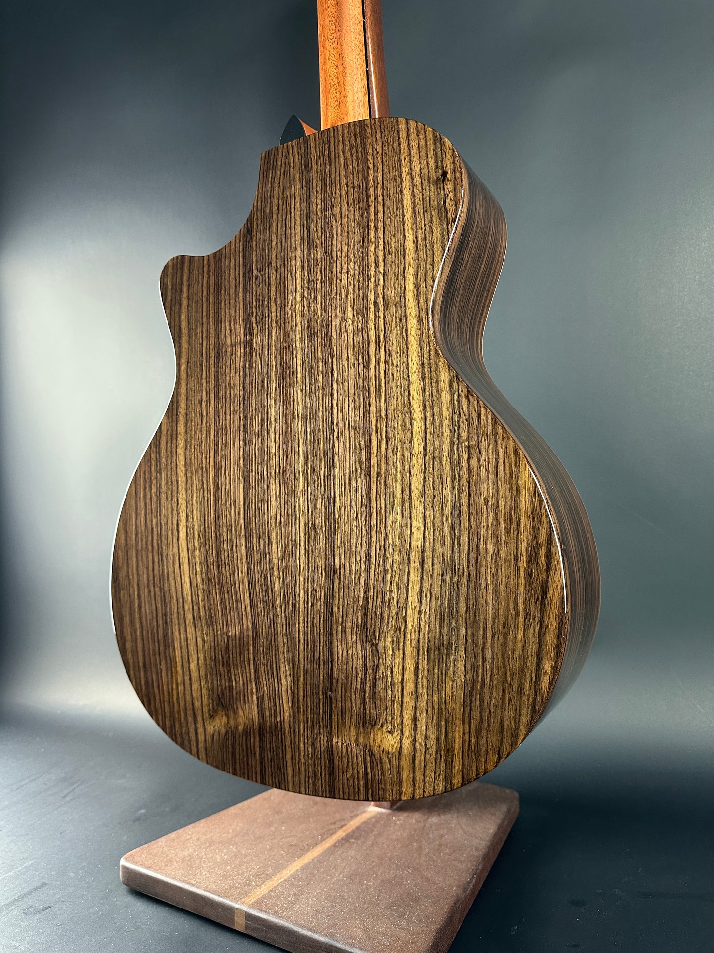Close-up of a wooden guitar body on a gray background