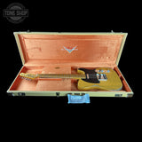 A gold-finish electric guitar inside an open hard case with a peach-pink velvet interior, shown against a black background. A Tone Shop watermark is visible in the top-left corner.