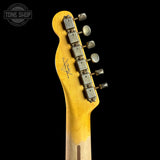 Close-up of the headstock of a Fender electric guitar with a natural wood finish and six tuning pegs, shown against a solid black background. A Tone Shop watermark is visible in the top left corner.