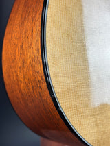 Close-up of a guitar's wooden soundboard with a white pickguard.