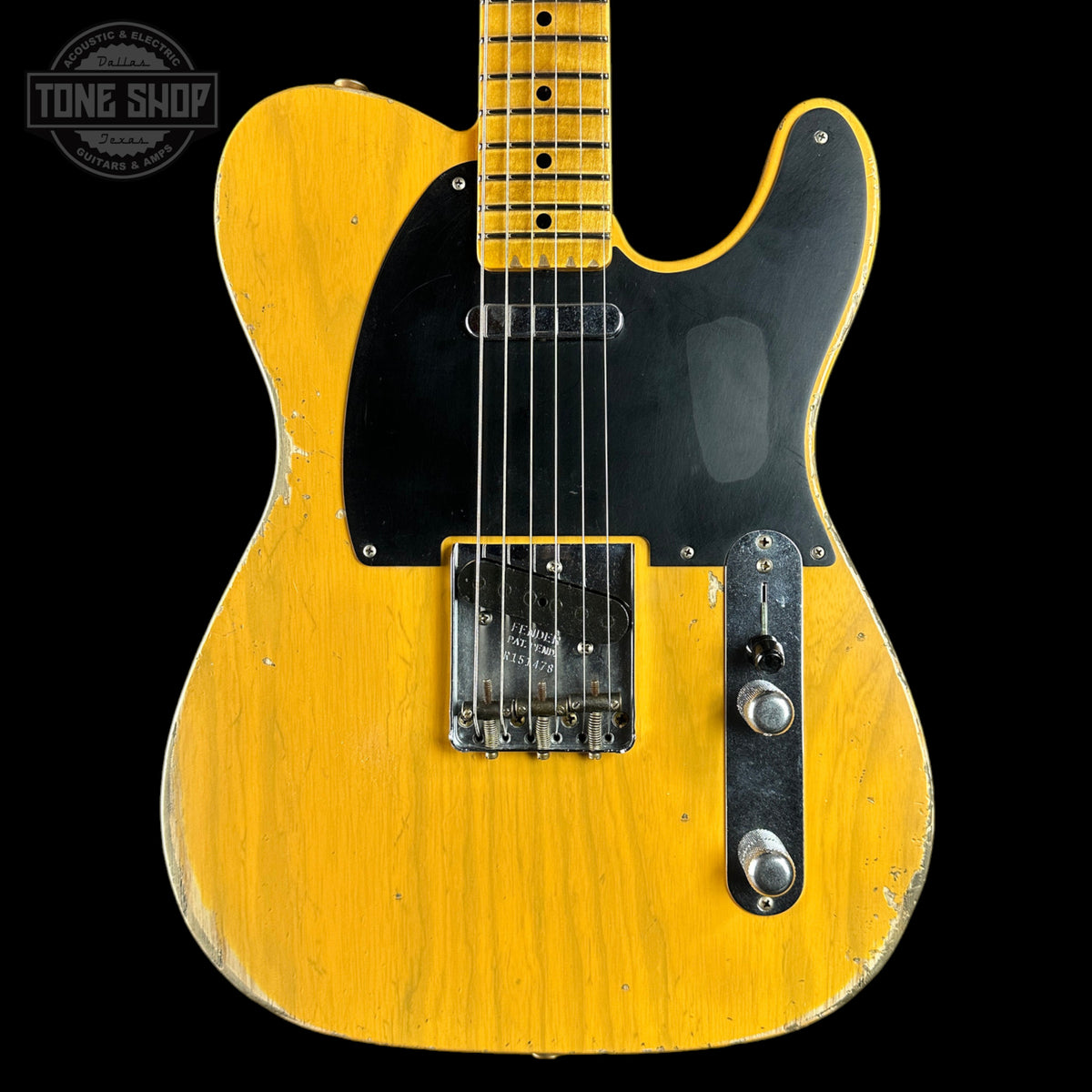 A vintage-style yellow electric guitar with a black pickguard, chrome hardware, and a maple neck, shown against a black background with a Tone Shop watermark in the top left corner.