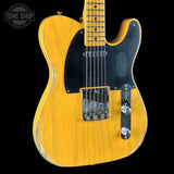 A Fender Telecaster electric guitar with a distressed yellow finish, black pickguard, and chrome hardware, shown against a solid black background with a Tone Shop watermark in the top left corner.