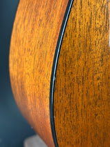 Close-up of a wooden guitar's body with a dark blue background
