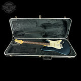 Electric guitar in a hard-shell case with 'Tone Shop' logo.