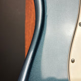 Close-up of a guitar's body and neck with a metallic finish.