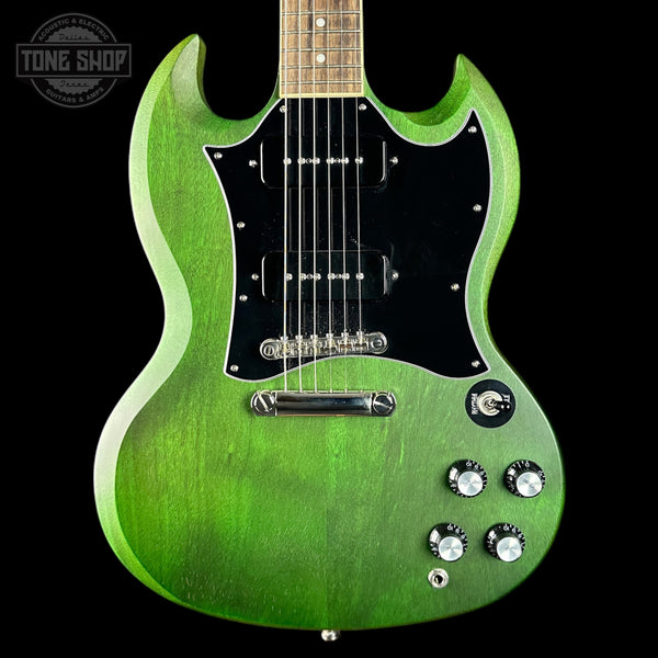 Green electric guitar with a black pickguard on a black background, featuring the Tone Shop logo.