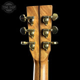 Close-up of a guitar headstock with tuning pegs on a black background, featuring the Tone Shop logo.