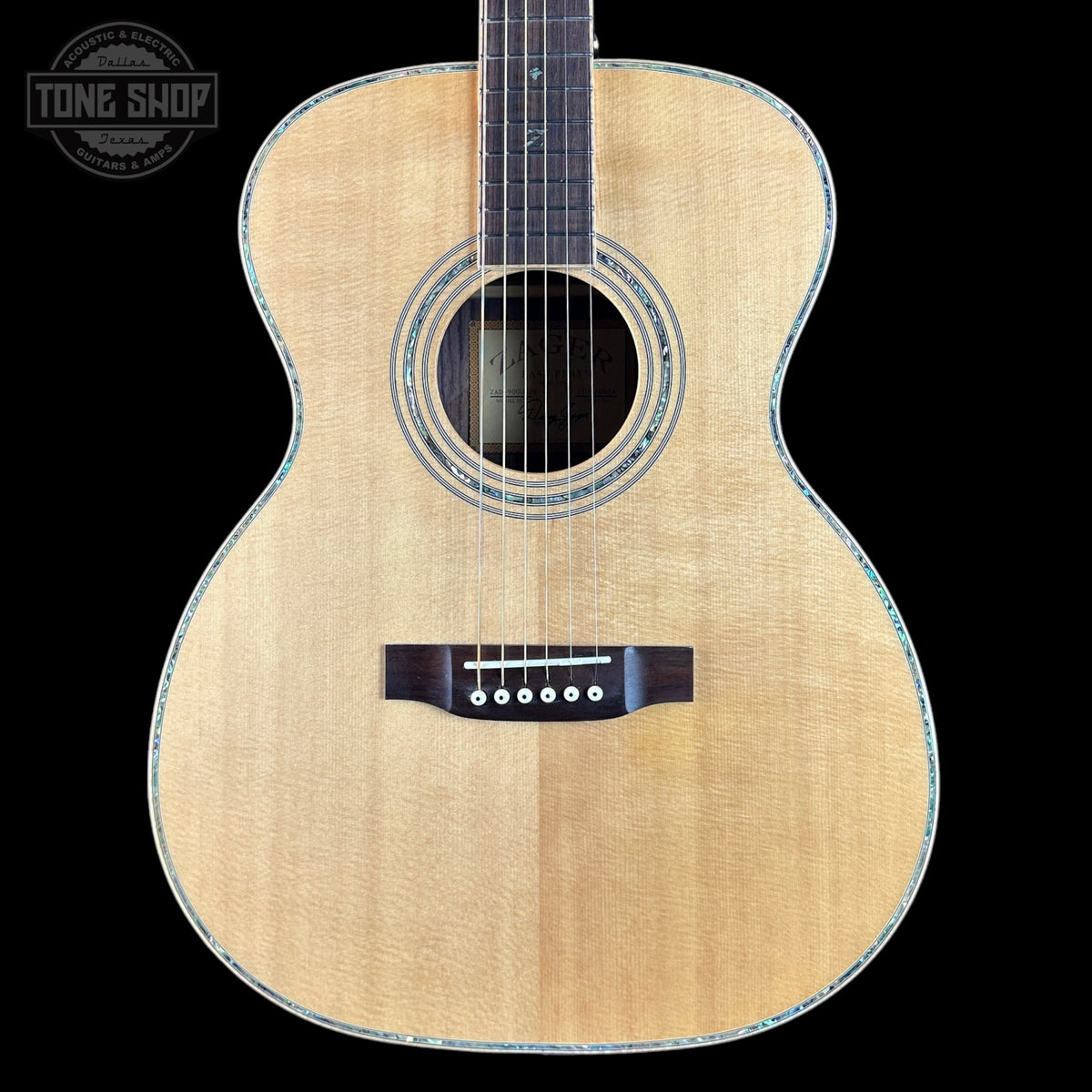 Acoustic guitar with a visible brand logo on a black background