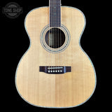 Acoustic guitar with a visible brand logo on a black background