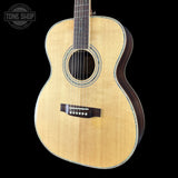 Acoustic guitar with a visible brand logo on a black background