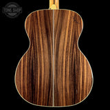 Close-up of a wooden acoustic guitar back with 'Tone Shop' logo.