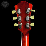 Close-up of a red guitar headstock with tuning pegs on a black background, featuring 'Tone Shop' branding.