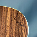 Close-up of a wooden surface with a signature on a blue gradient background