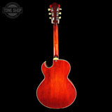 Red electric guitar on a black background with 'Tone Shop' logo.