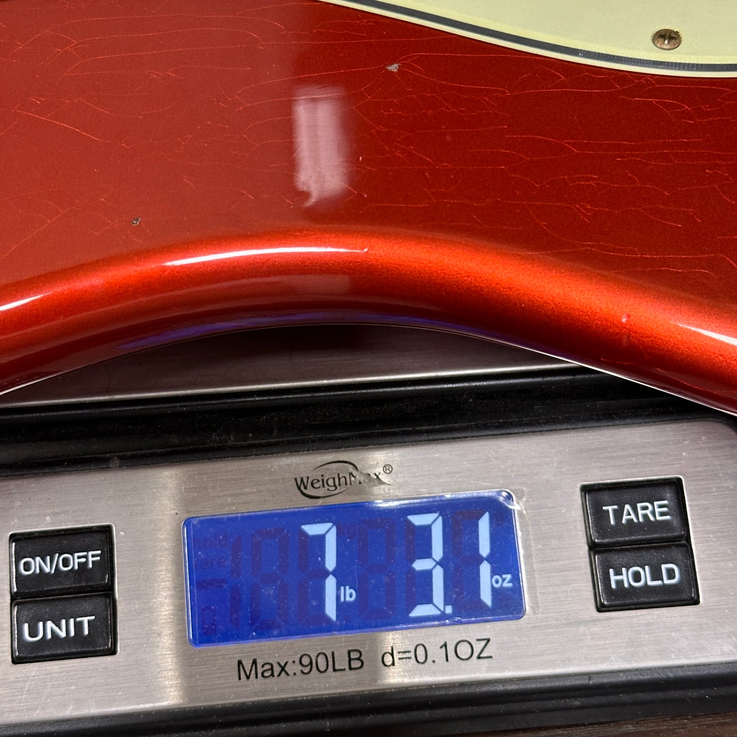 Digital scale displaying weight with a red object on top