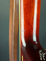 Close-up of a wooden guitar neck with a dark gray background