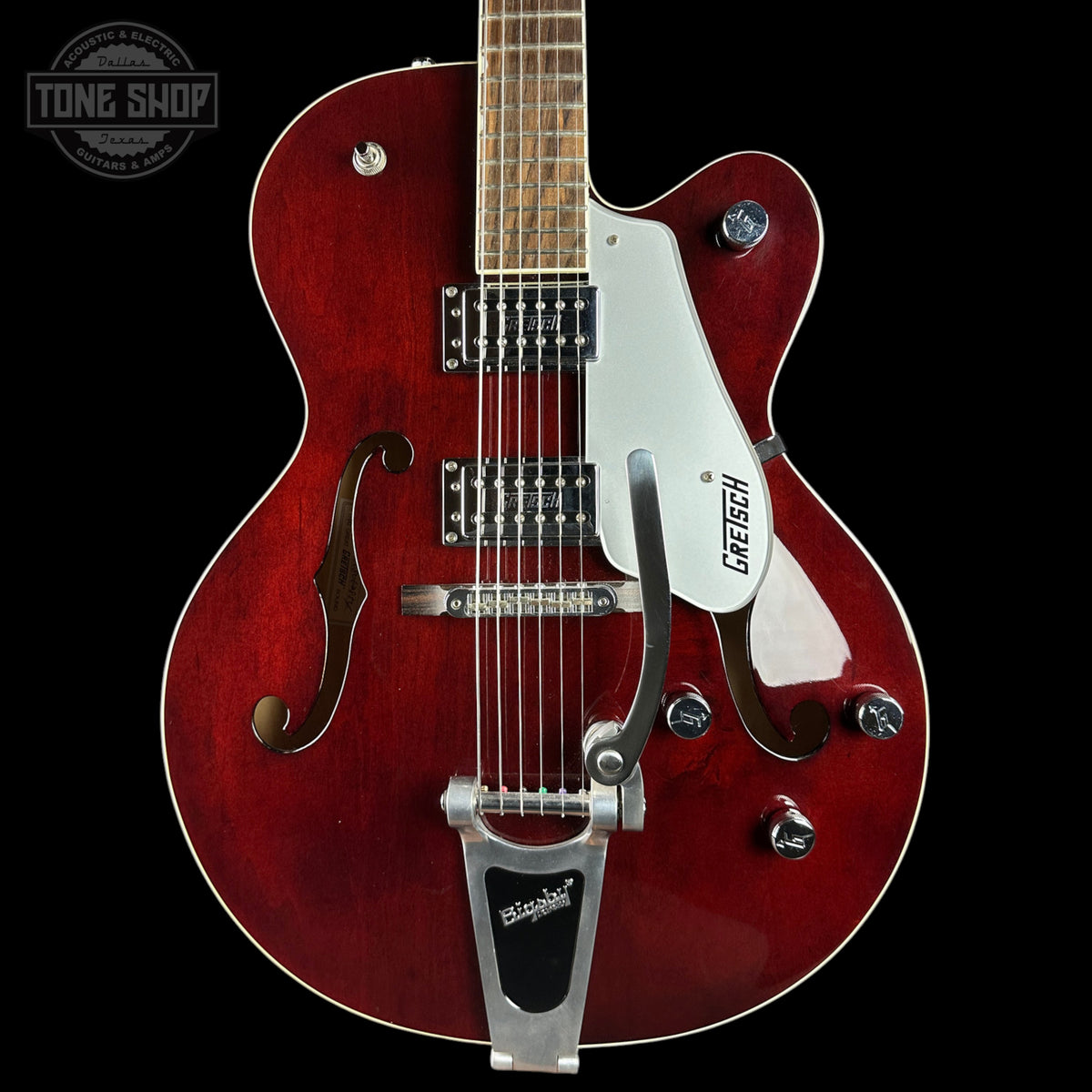 Red electric guitar with a Gretsch logo on a black background