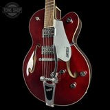 Red electric guitar with Gretsch logo on a black background