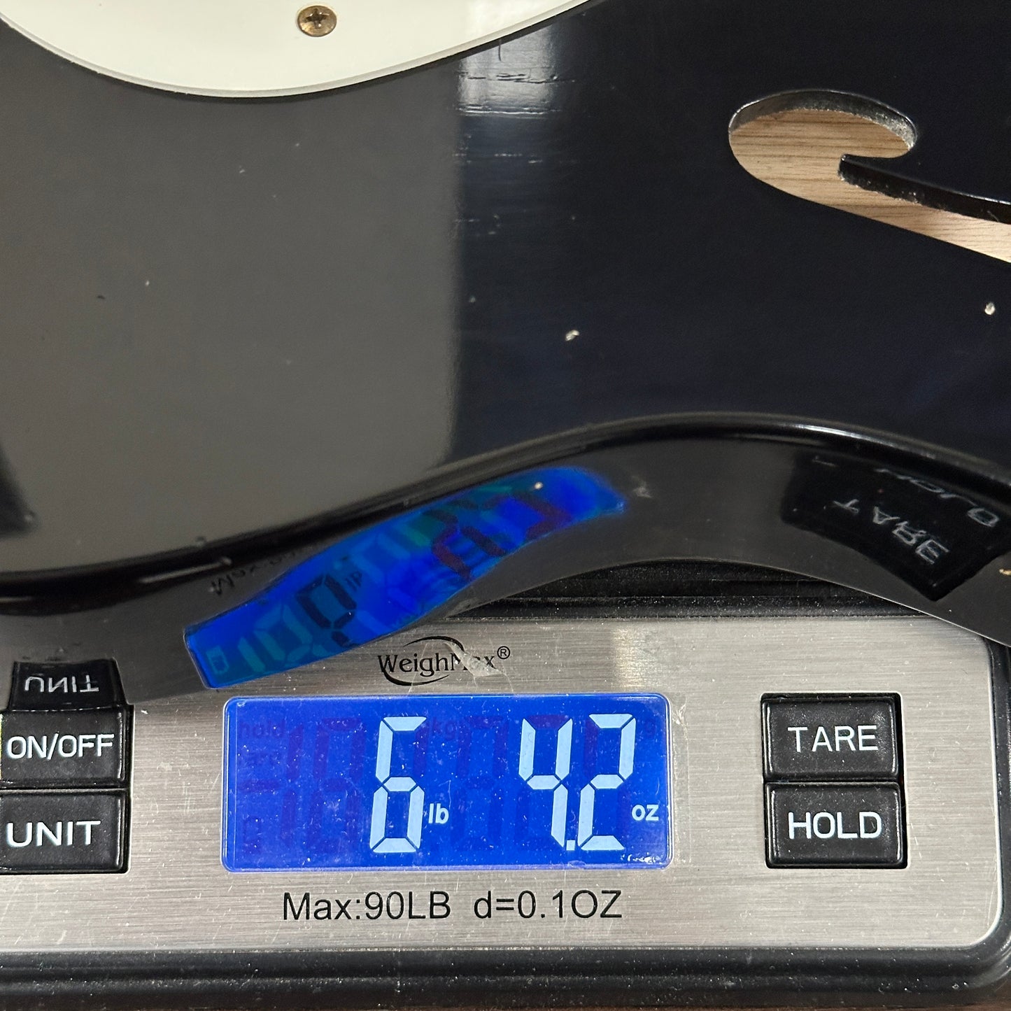 Digital scale displaying weight with a guitar on top