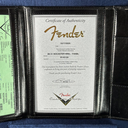 Fender certificate of authenticity in a black leather holder on a blue background