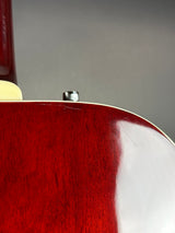 Close-up of a red guitar with a blurred gray background
