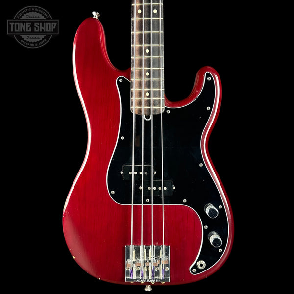 Red electric bass guitar on a black background with 'Tone Shop' logo.