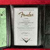 Fender certificate of authenticity in a black leather holder on a red background