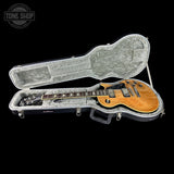 Electric guitar in a hard-shell case with 'Tone Shop' branding.