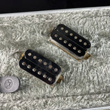 Two guitar pickups on a textured surface