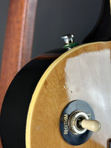 Close-up of a guitar's pickup selector switch with 'RHYTHM' label on a wooden surface.